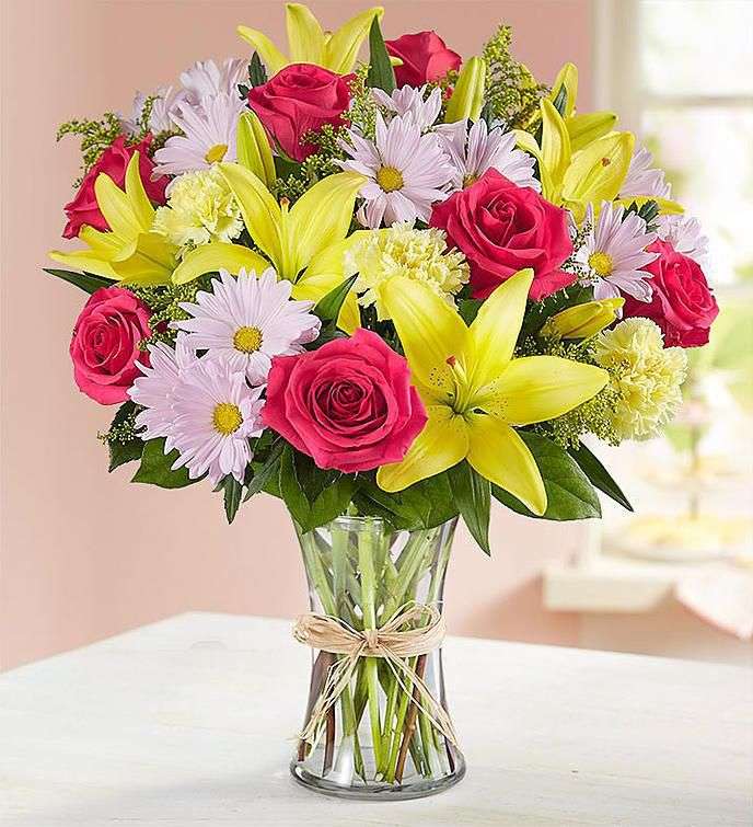 Букет білих, жовтих і червоних квітів у скляній вазі онлайн пазл