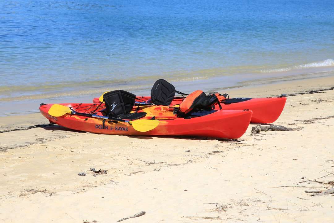 Kayak rosso sulla spiaggia di sabbia bianca durante il giorno puzzle online