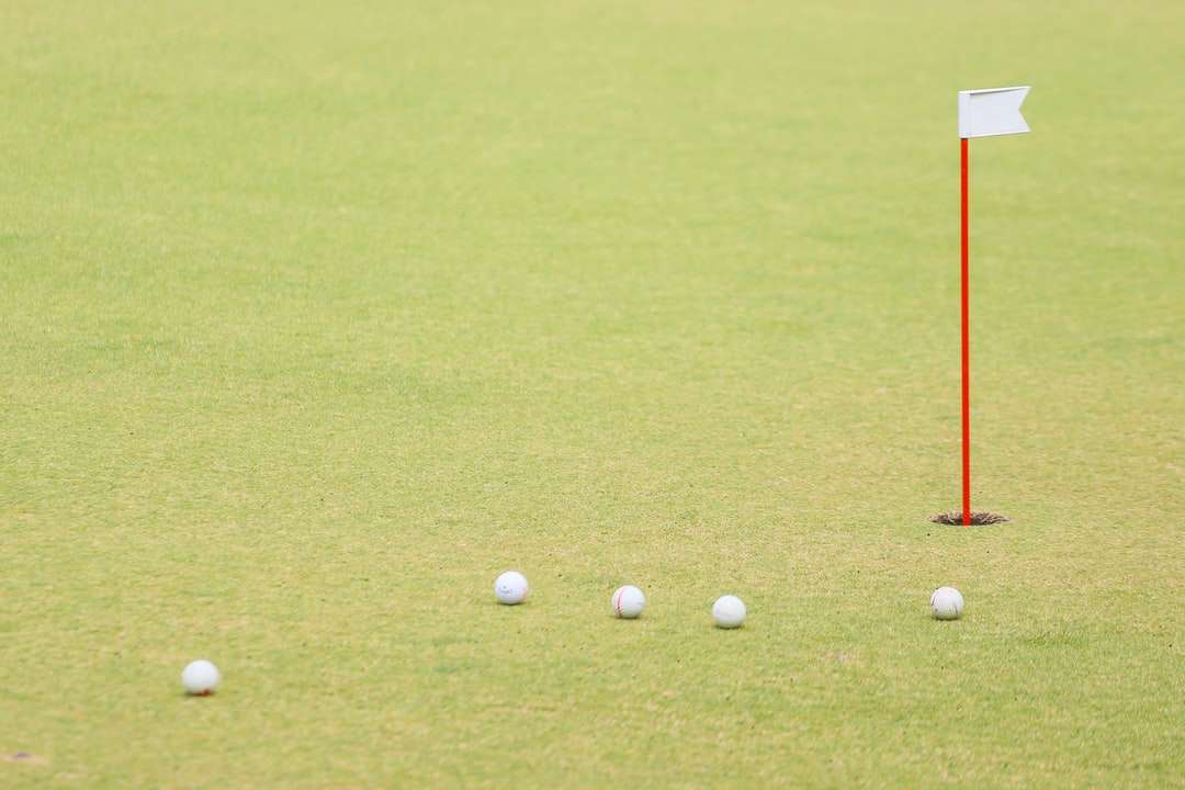 мяч для гольфа на поле с зеленой травой в дневное время пазл онлайн