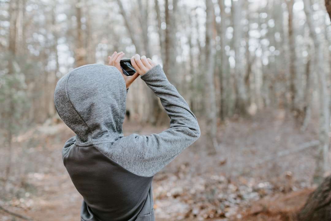Muž v šedém svetru drží černý fotoaparát skládačky online