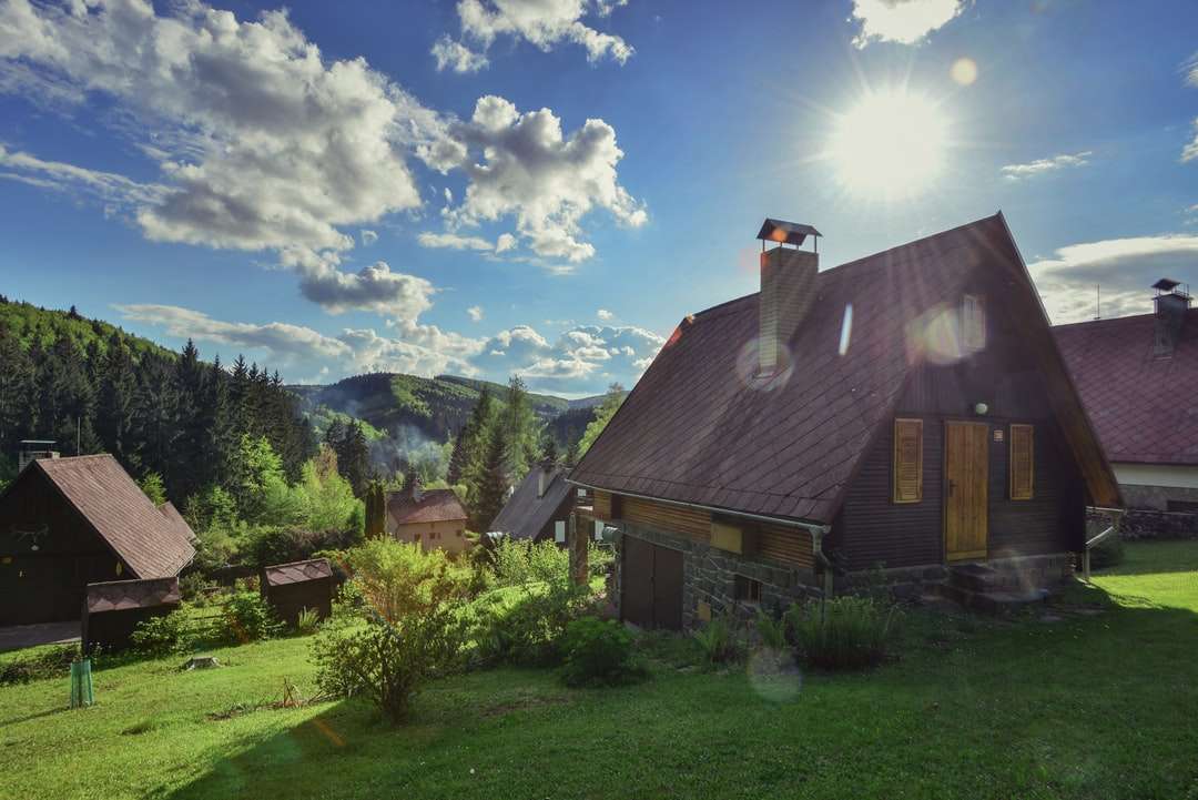 barna és szürke ház zöld fák közelében kék ég online puzzle