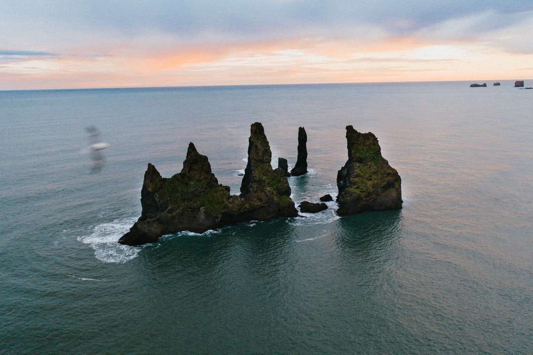 Formazione rocciosa marrone sul mare blu durante il giorno puzzle online