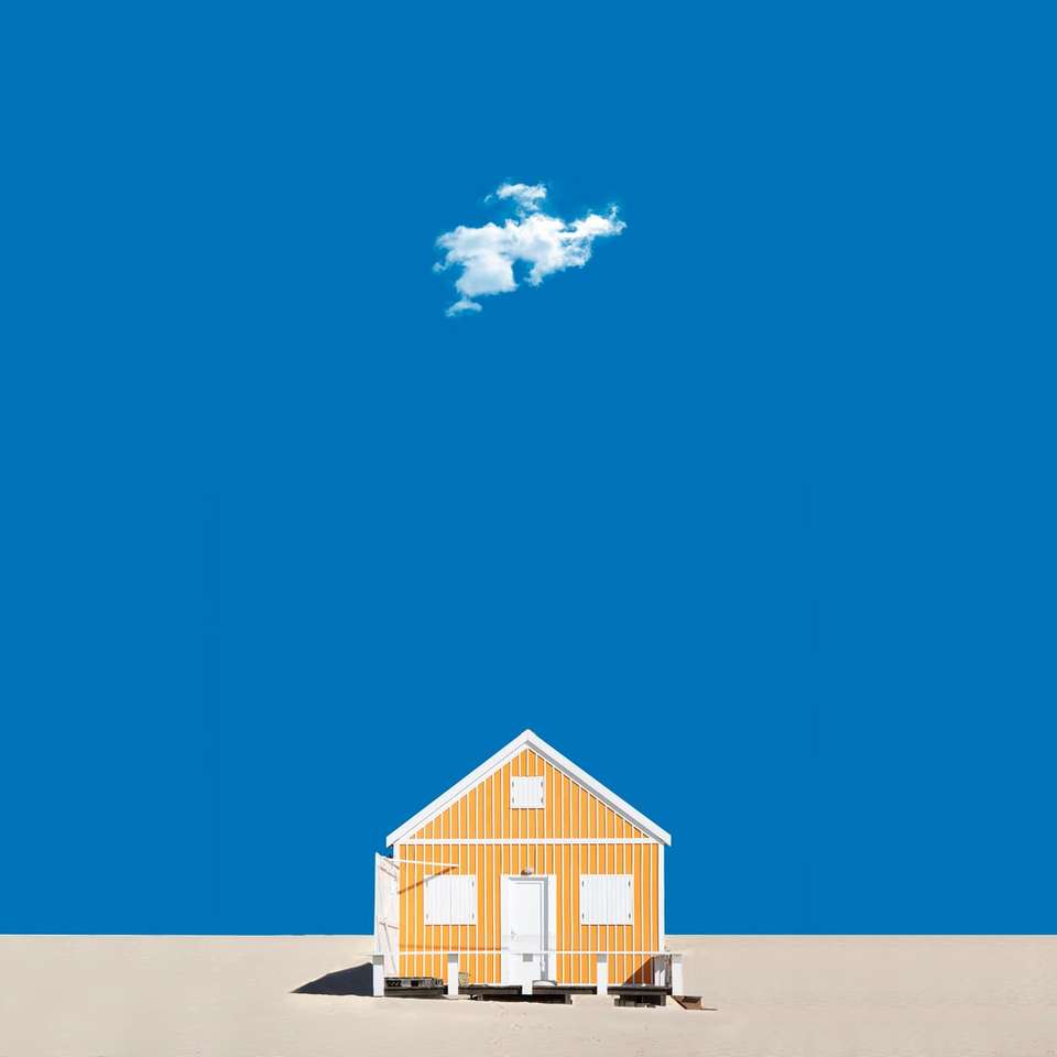 Weißes und braunes Holzhaus unter blauem Himmel tagsüber Online-Puzzle