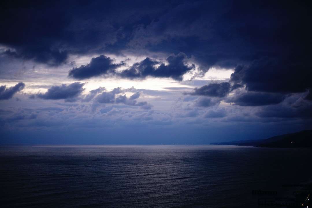 Μπλε ουρανό και λευκά σύννεφα πάνω από τη θάλασσα παζλ online