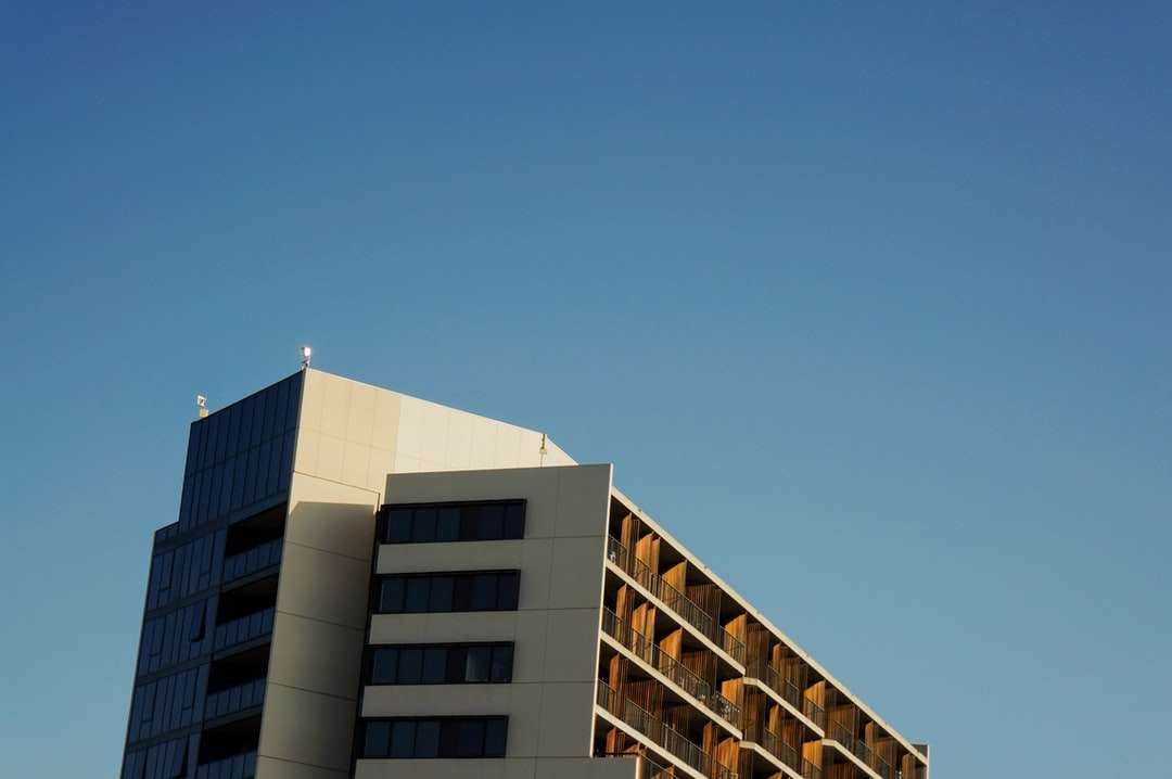Vit och brun betongbyggnad under blå himmel Pussel online
