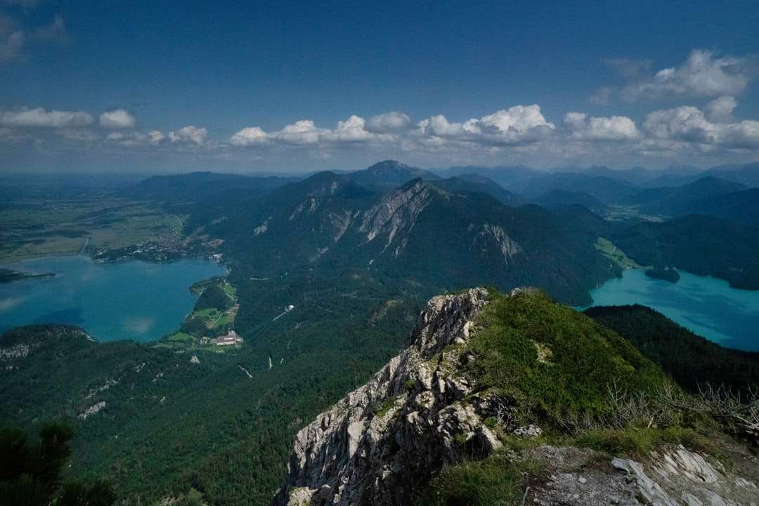 Munții verzi lângă corpul de apă sub cerul albastru puzzle online
