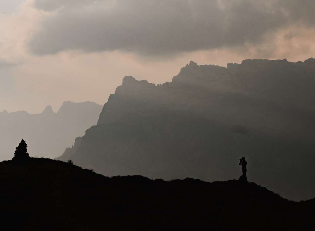 silhouette of person standing on rock formation online puzzle