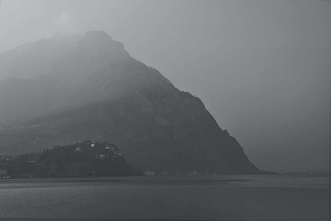Corpo de água perto da montanha durante o clima nebuloso puzzle online