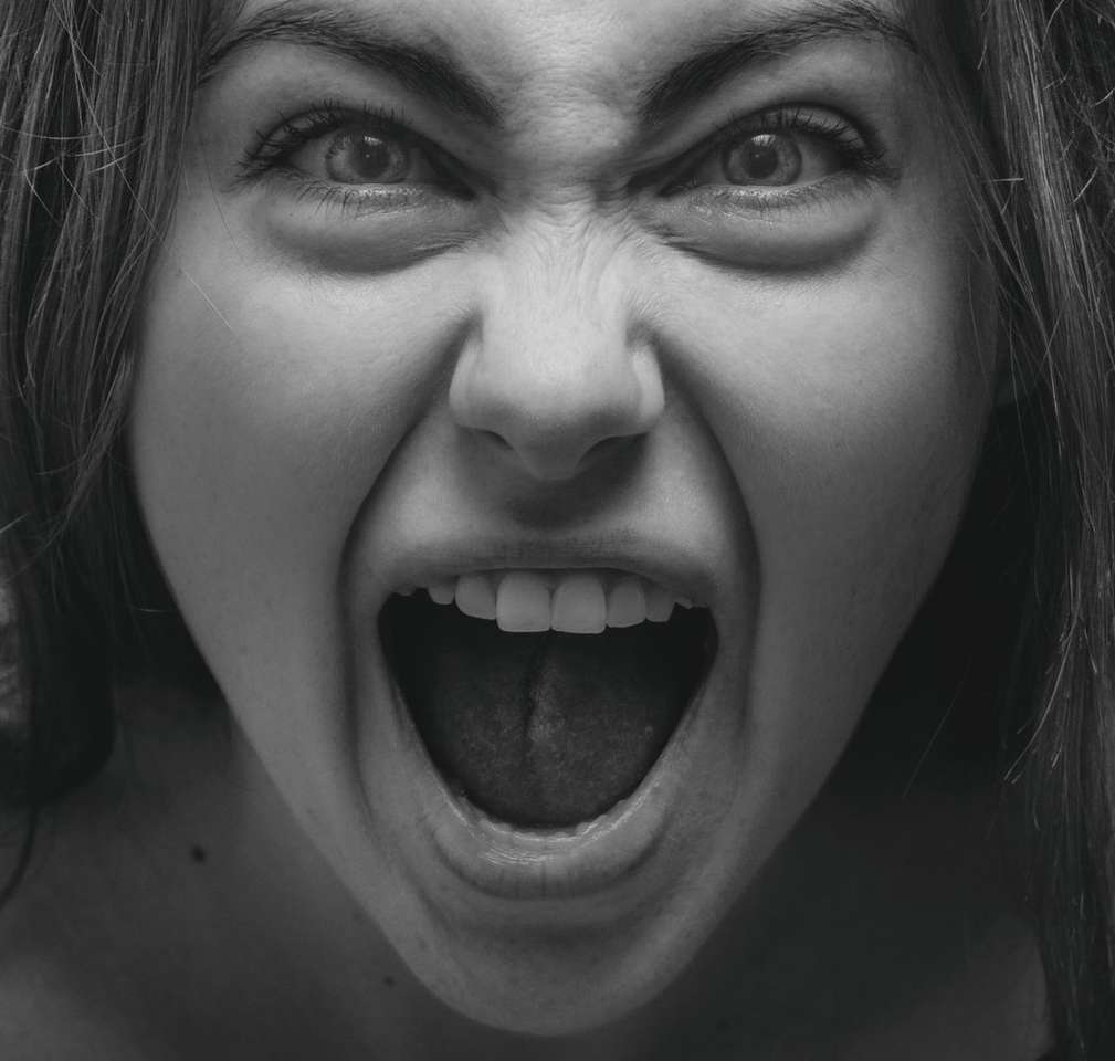 Foto en escala de grises de mujer que muestra su lengua. rompecabezas en línea