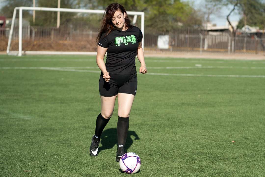 Женщина в черной футбольной майке Nike пинает футбольный мяч пазл онлайн