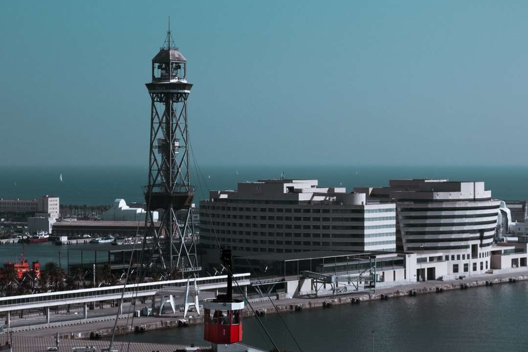 Torre bianca e rossa vicino al corpo dell'acqua durante il giorno puzzle online