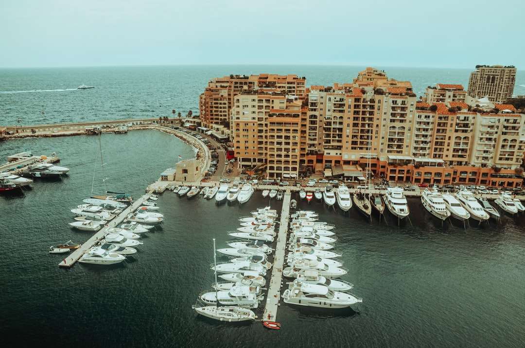 Barco branco e marrom no mar perto de edifícios da cidade quebra-cabeças online