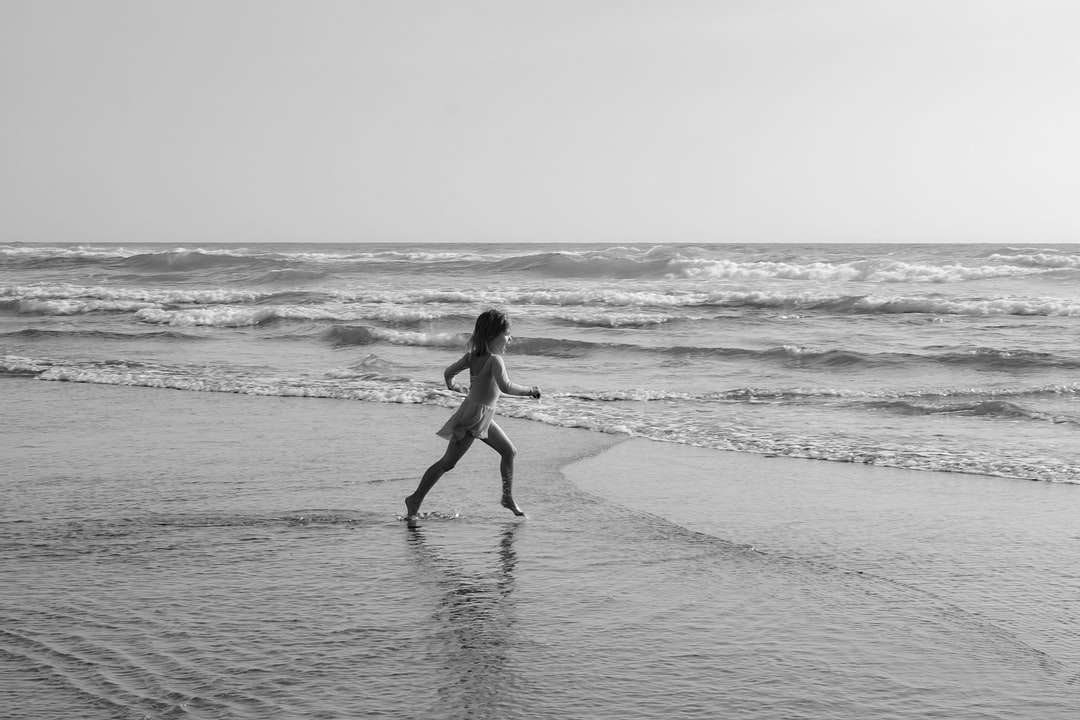 昼間にビーチを歩いている黒いビキニの女性 ジグソーパズルオンライン