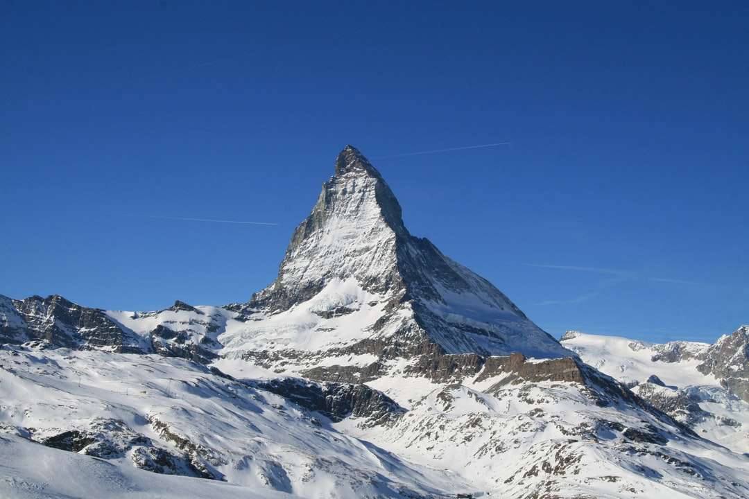 Montaña cubierta de nieve bajo el cielo azul durante el día rompecabezas en línea