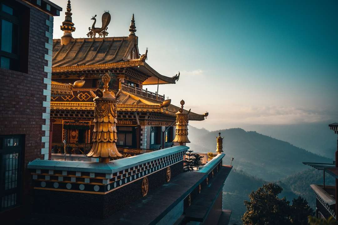 brunt och grönt tempel på toppen av berget under dagtid Pussel online