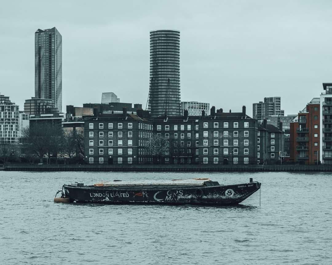 Fekete-fehér csónak a víz közelében városi épületek online puzzle