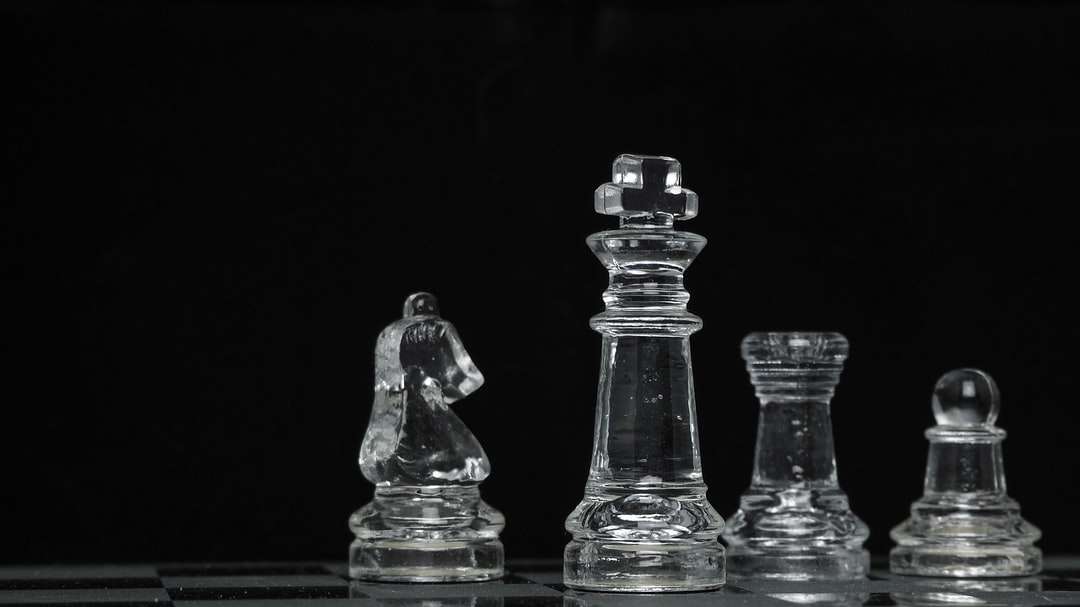 Klar glas schackstycke på svart yta Pussel online