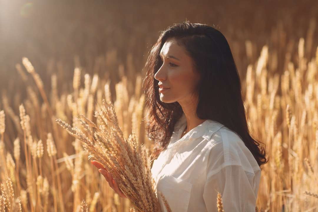 Donna in camicia bianca che sta sul campo di erba marrone puzzle online