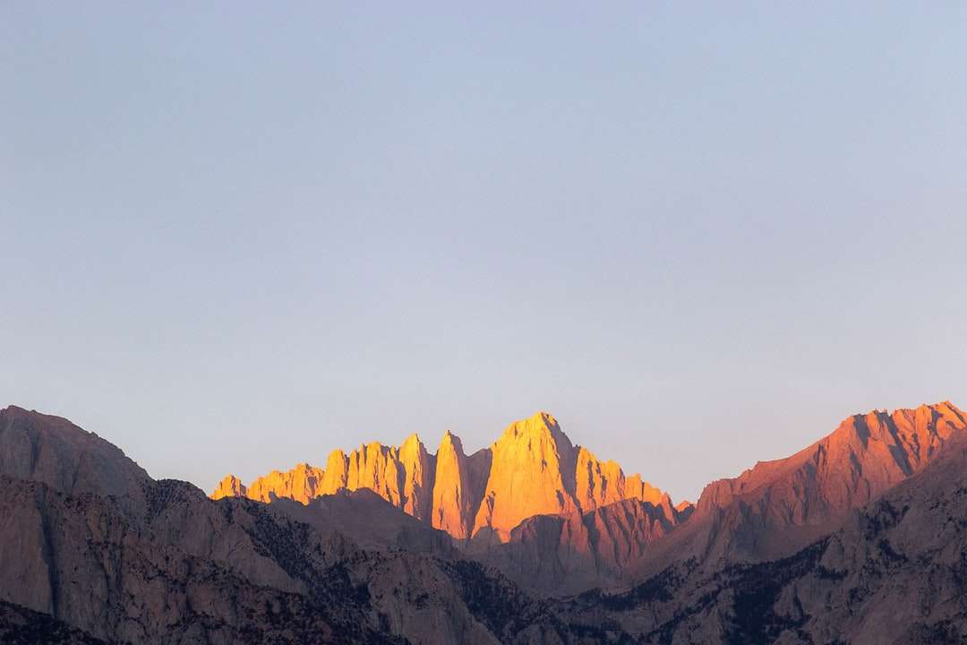 Bruine rotsachtige bergen onder witte hemel overdag online puzzel