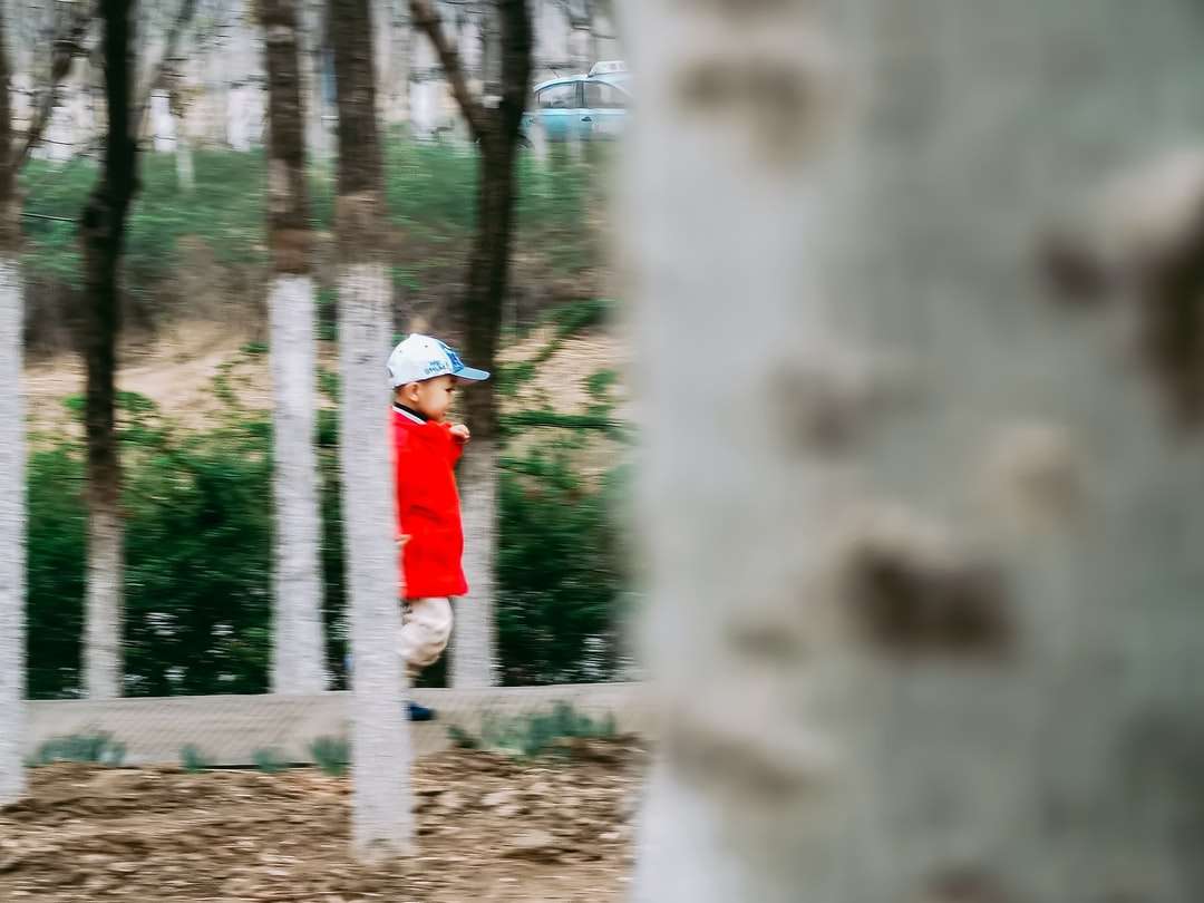 човек в червена и бяла шапка, стояща близо до дърветата онлайн пъзел