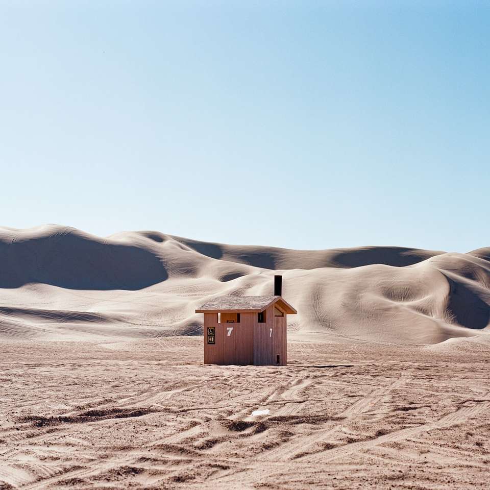 Hnědý dřevěný dům na bílém zasněžené hory skládačky online