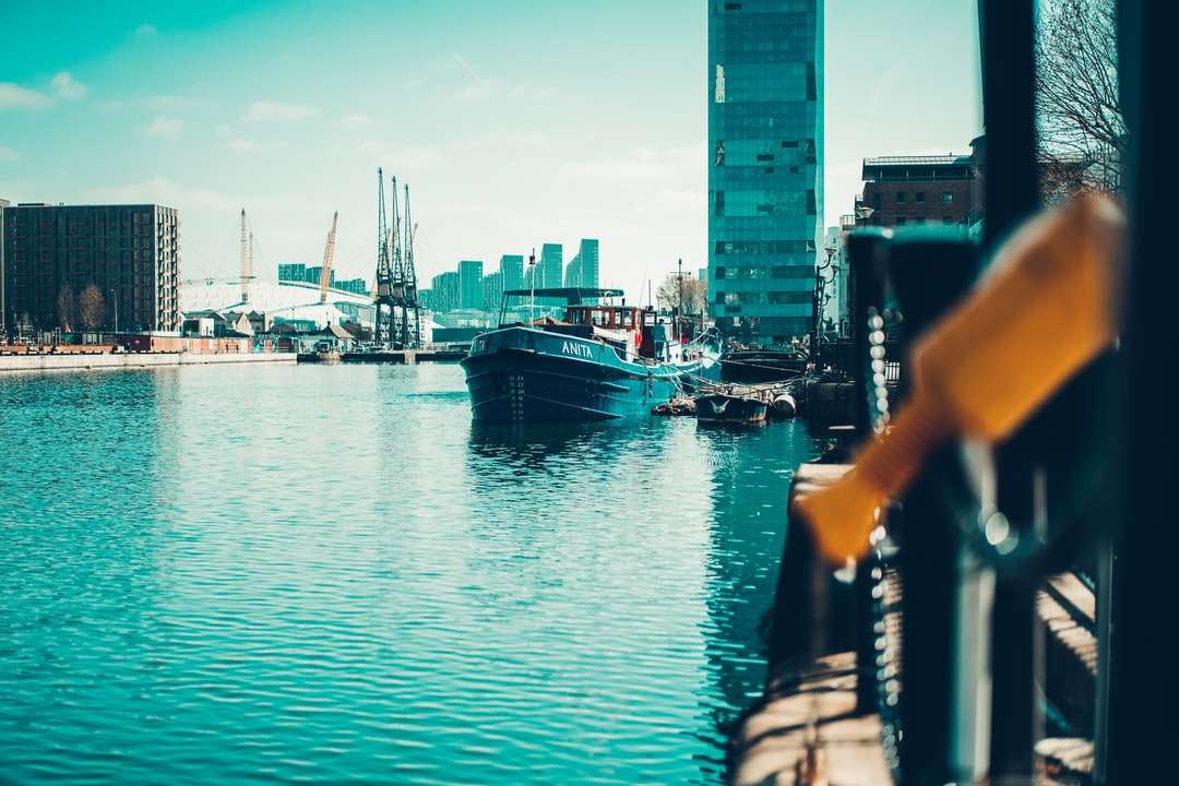 Barco na água perto de edifícios da cidade durante o dia puzzle online
