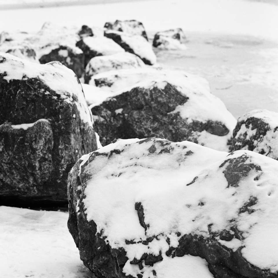 Grijze en zwarte rotsformatie op witte sneeuw overdag legpuzzel online