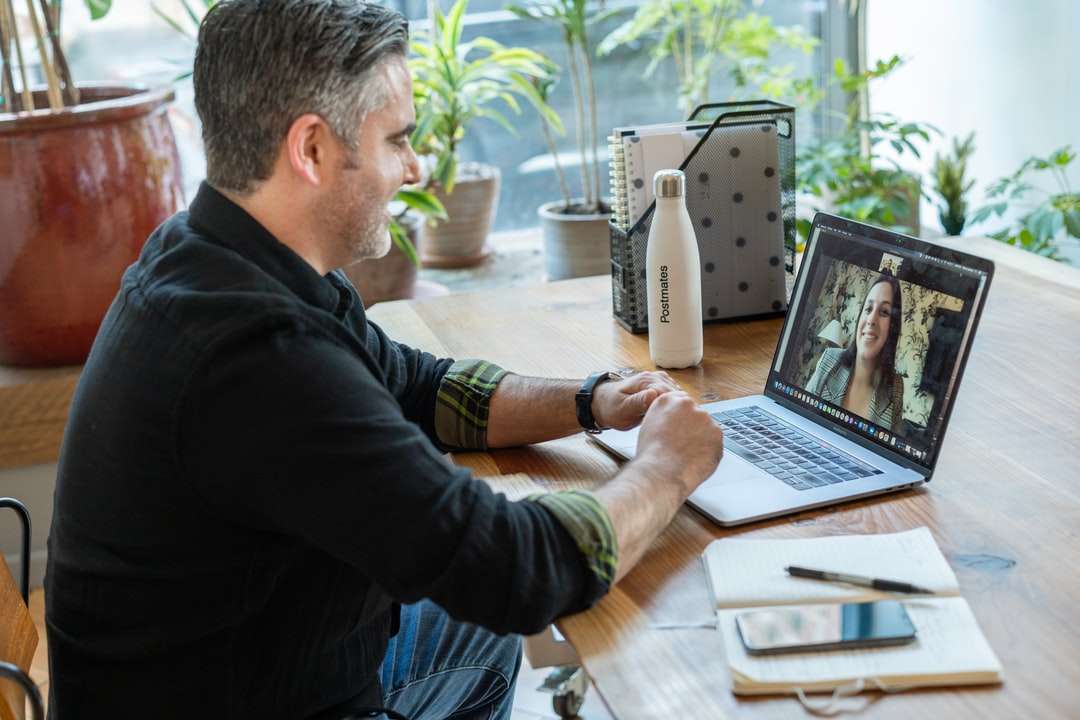 Homme en pull noir utilisant MacBook Pro puzzle en ligne