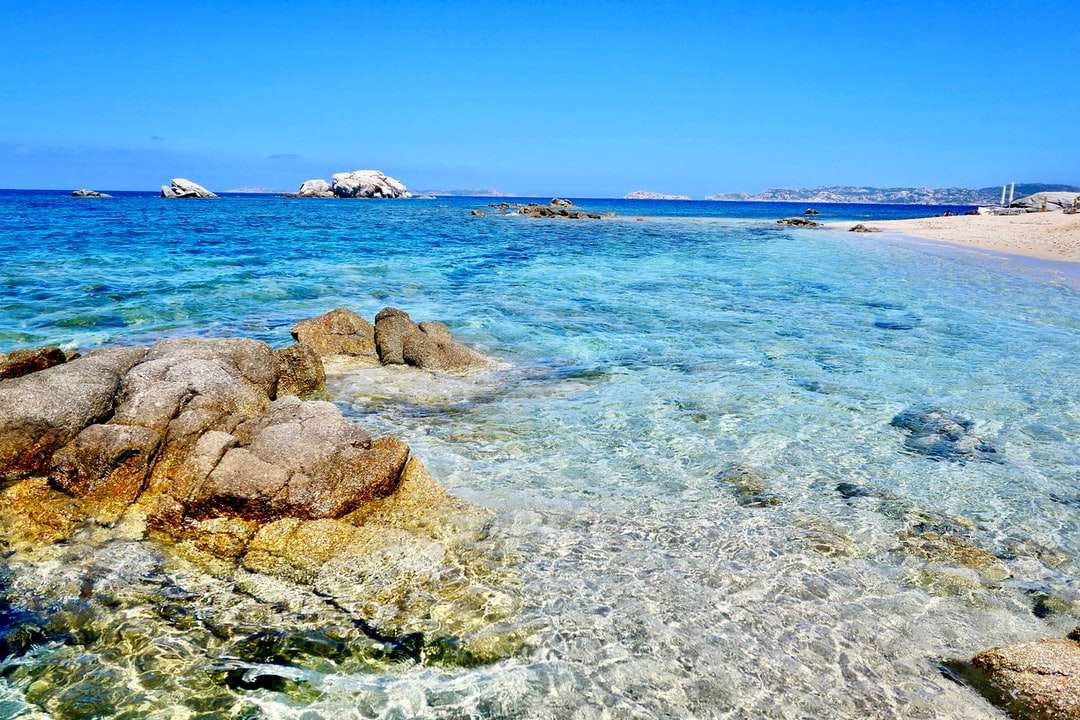 barna sziklák kék tenger alatt kék ég alatt nappali kirakós online