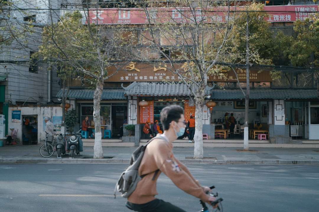 Ο άνθρωπος σε μαύρα σορτς που οδηγεί στο ποδήλατο στο δρόμο κατά τη διάρκεια της ημέρας online παζλ