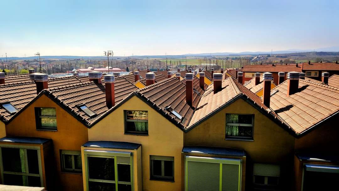 Braune und grüne Betonhäuser unter blauem Himmel Puzzlespiel online