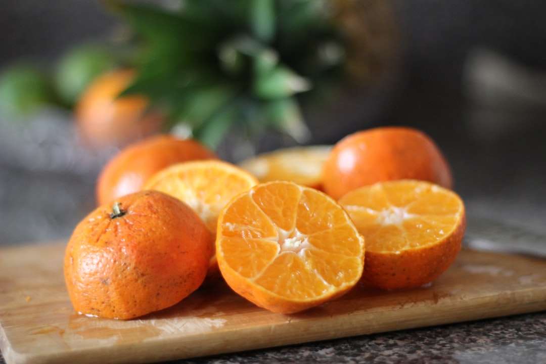 Szeletelt narancssárga gyümölcs barna fából készült tálcán kirakós online