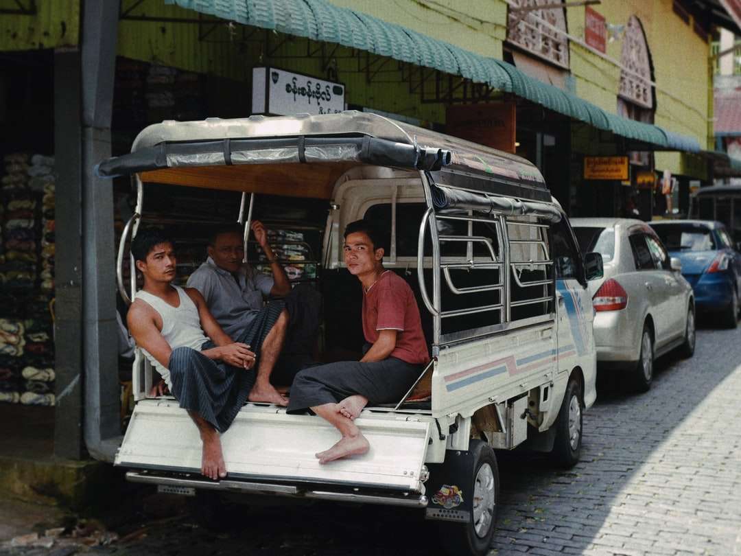3 чоловіки сидять на біло-зеленій машині онлайн пазл