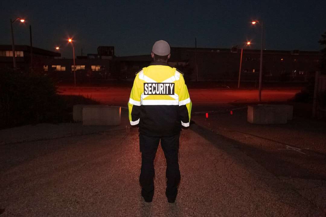 Ο άνθρωπος σε κίτρινο και μαύρο σακάκι που στέκεται στο πεζοδρόμιο online παζλ