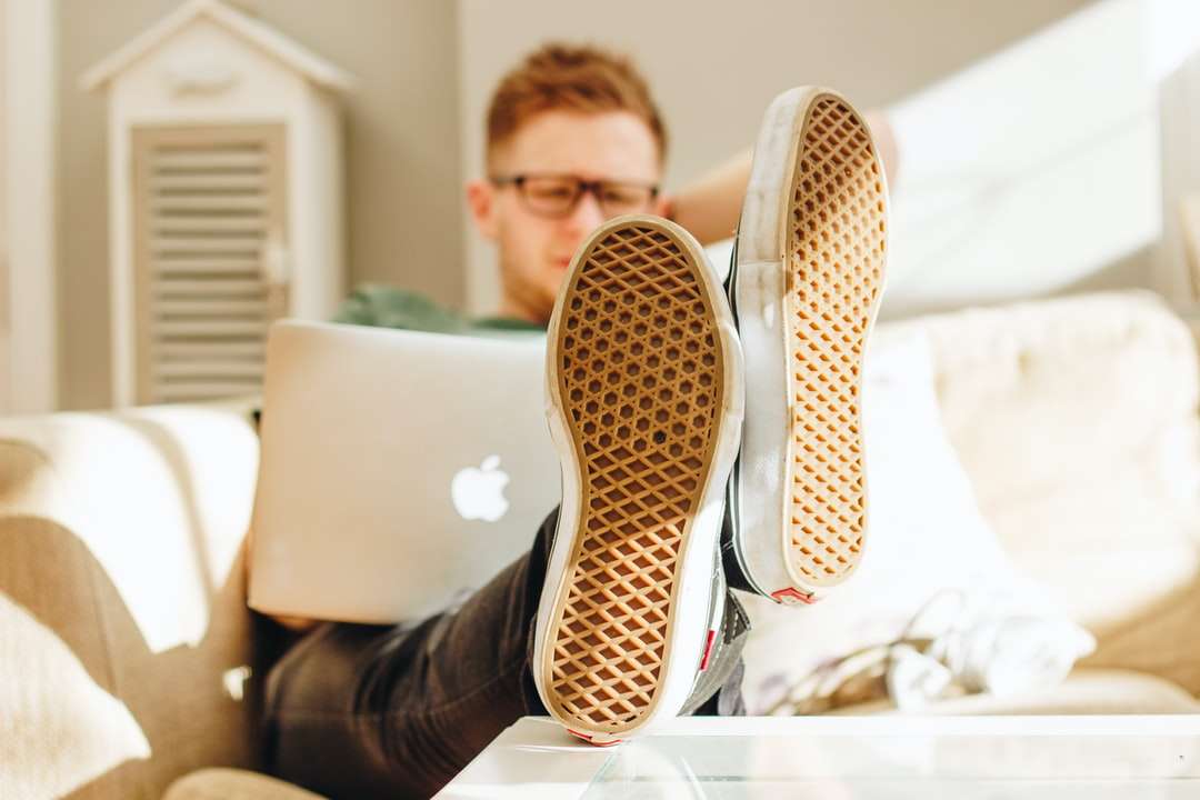 Ο άνθρωπος σε μαύρο και άσπρο πάνινα παπούτσια που κάθεται σε λευκό καναπέ online παζλ