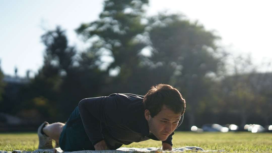 Az ember fekete hosszú ujjú póló ül a zöld fű mezőben online puzzle