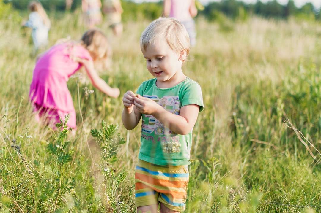 Fille en T-shirt rose debout sur le champ d'herbe verte puzzle en ligne