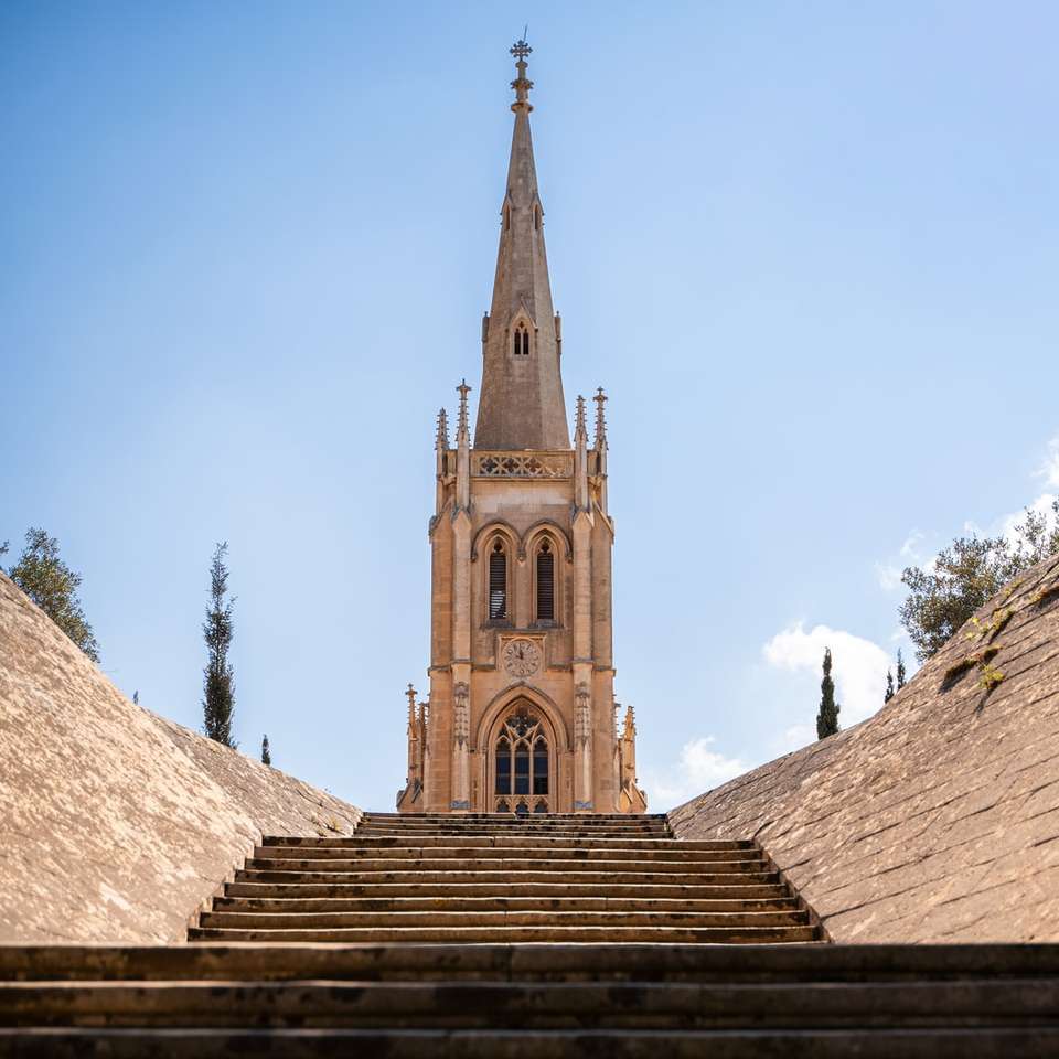 hnědý betonový kostel pod modrou oblohu během dne skládačky online