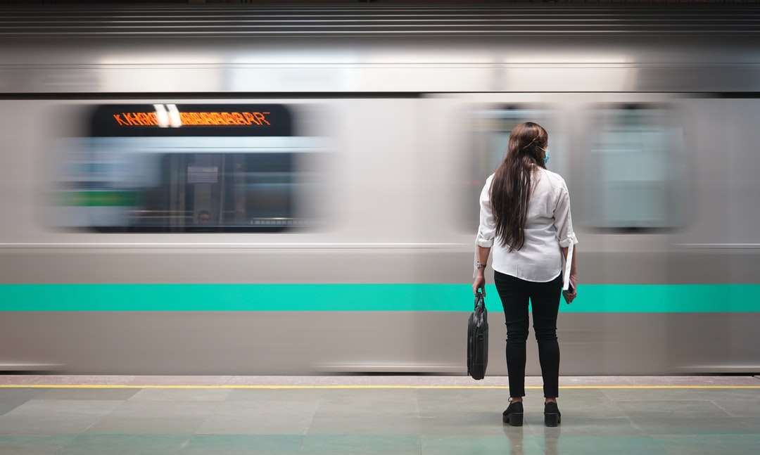 женщина в белой куртке стоит у поезда онлайн-пазл