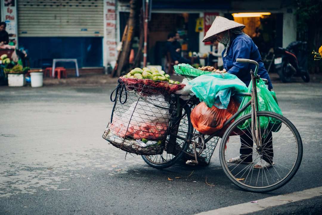 Person i grön jacka ridning cykel med grönsaker Pussel online