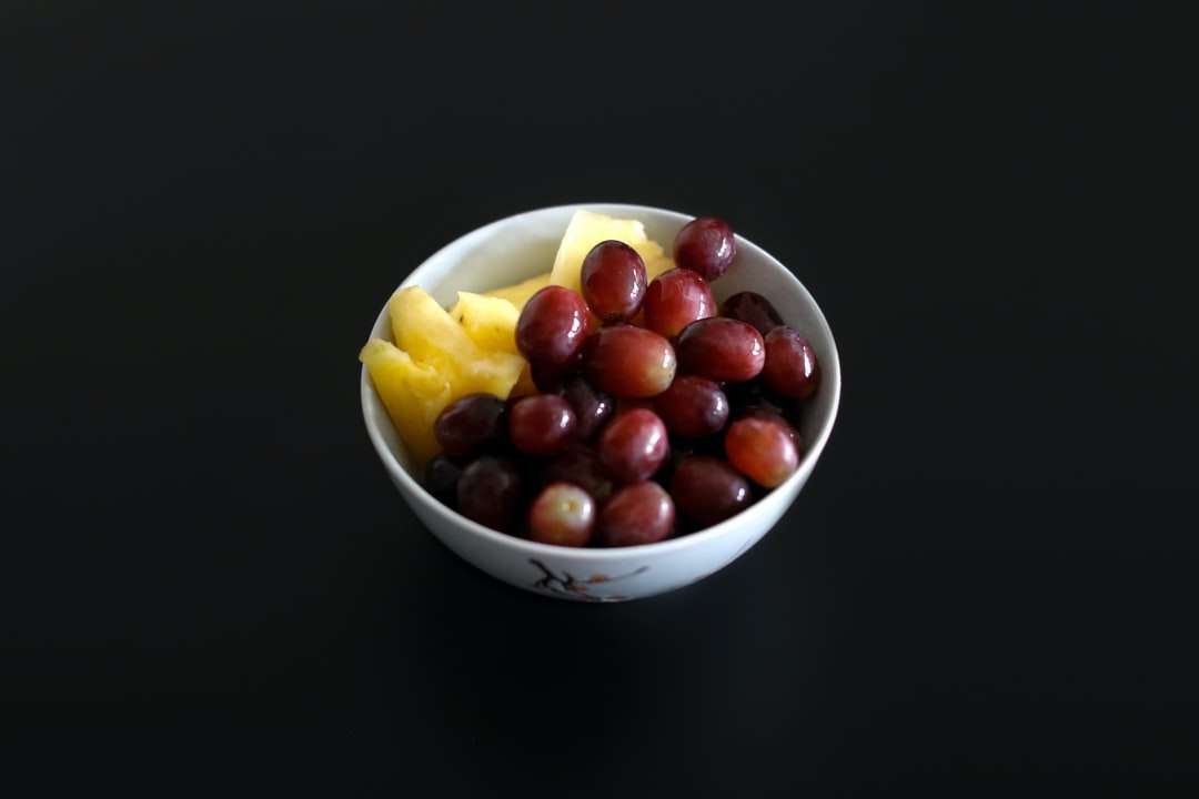 Frutas redondas rojas en el tazón de cerámica blanco rompecabezas en línea