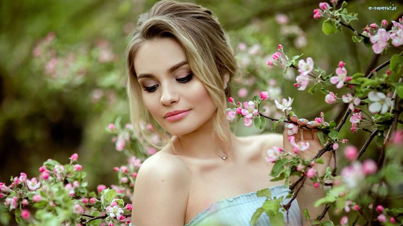 Жінка серед квітучих дерев онлайн пазл