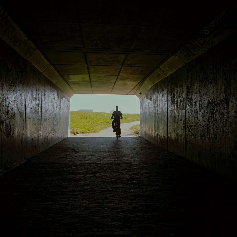 Man in zwarte jas die op tunnel loopt online puzzel