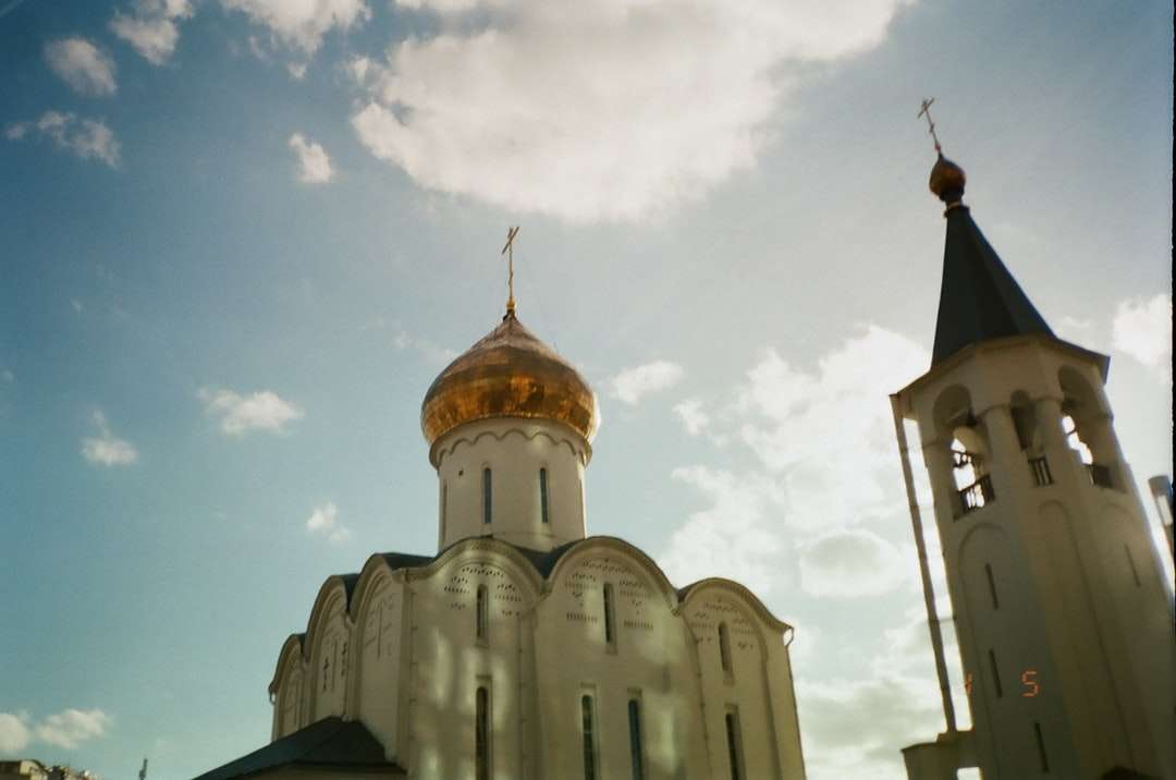 Igreja concreta branca e marrom sob o céu azul quebra-cabeças online