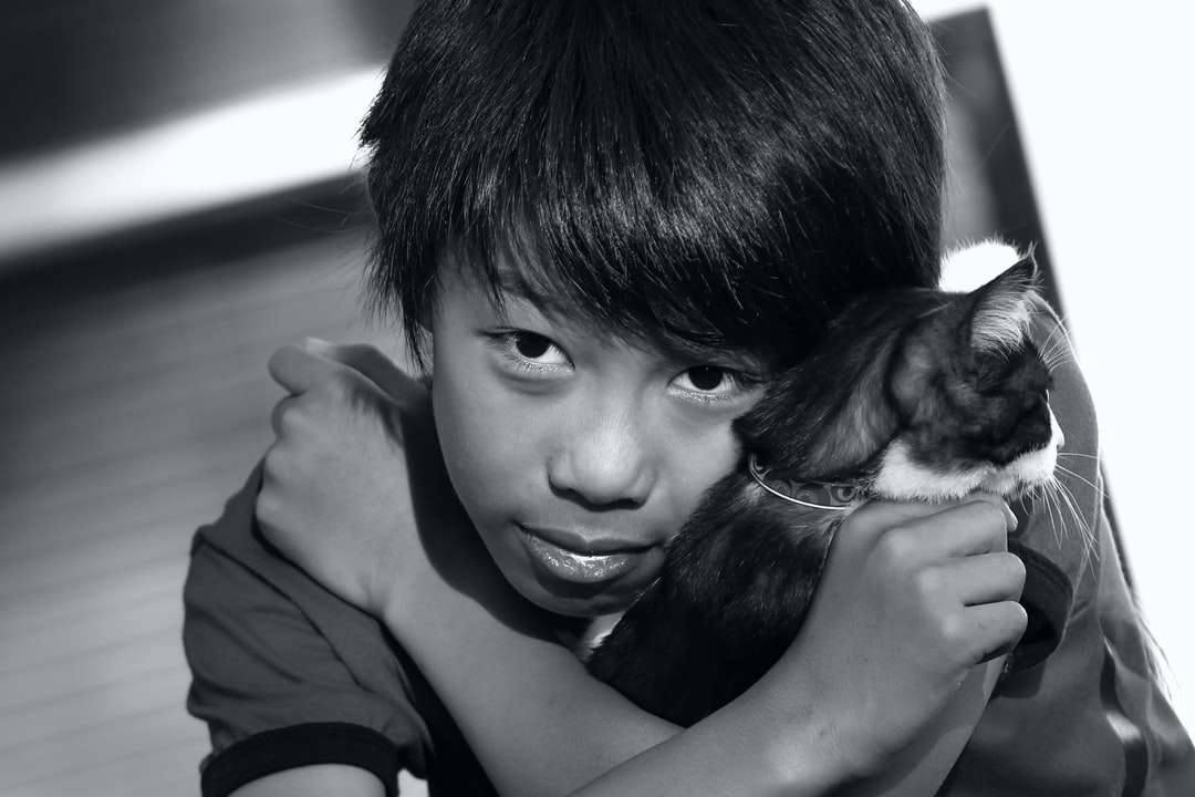 Grayscale Foto av Boy Holding Puppy Pussel online
