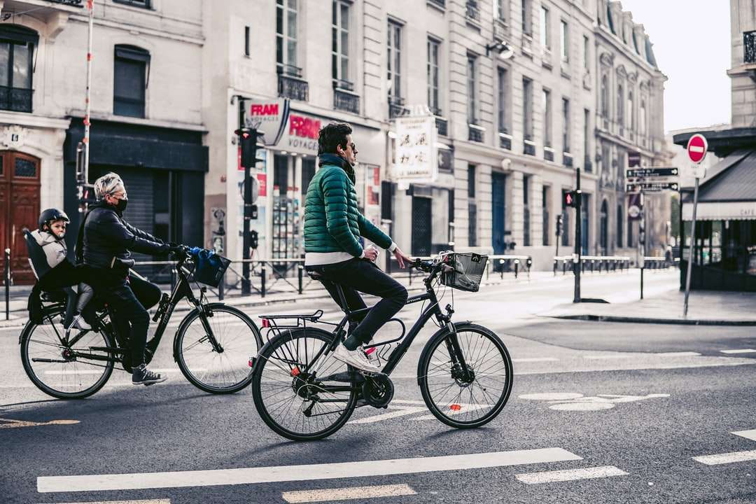 Man in groen jasje rijden op zwarte fiets op de weg online puzzel