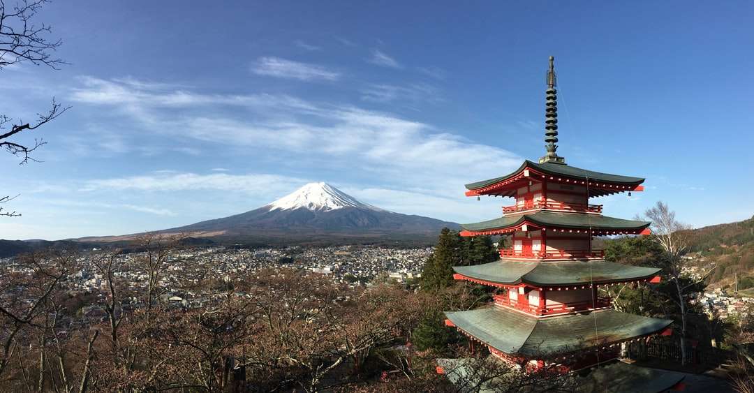 Червен и бял храм близо до планина под синьо небе онлайн пъзел