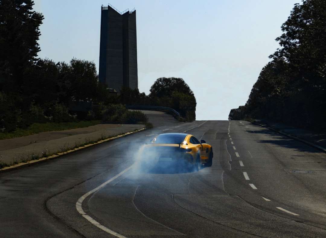 Carro de esportes amarelo e preto na estrada durante o dia quebra-cabeças online