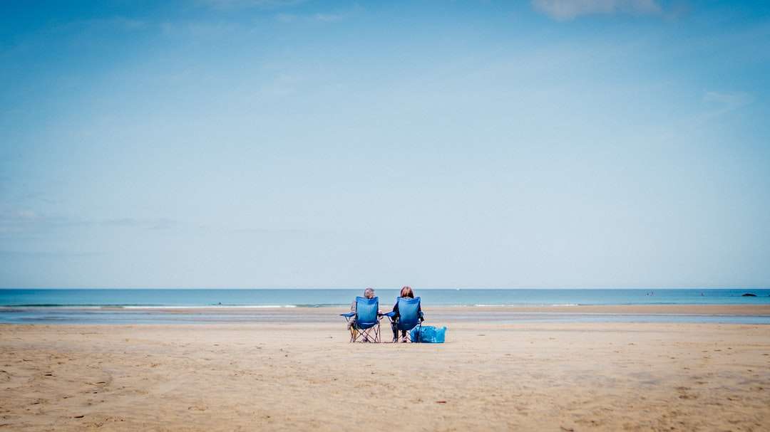2 Person, die am Strand an der Tagesuhr sitzt Online-Puzzle