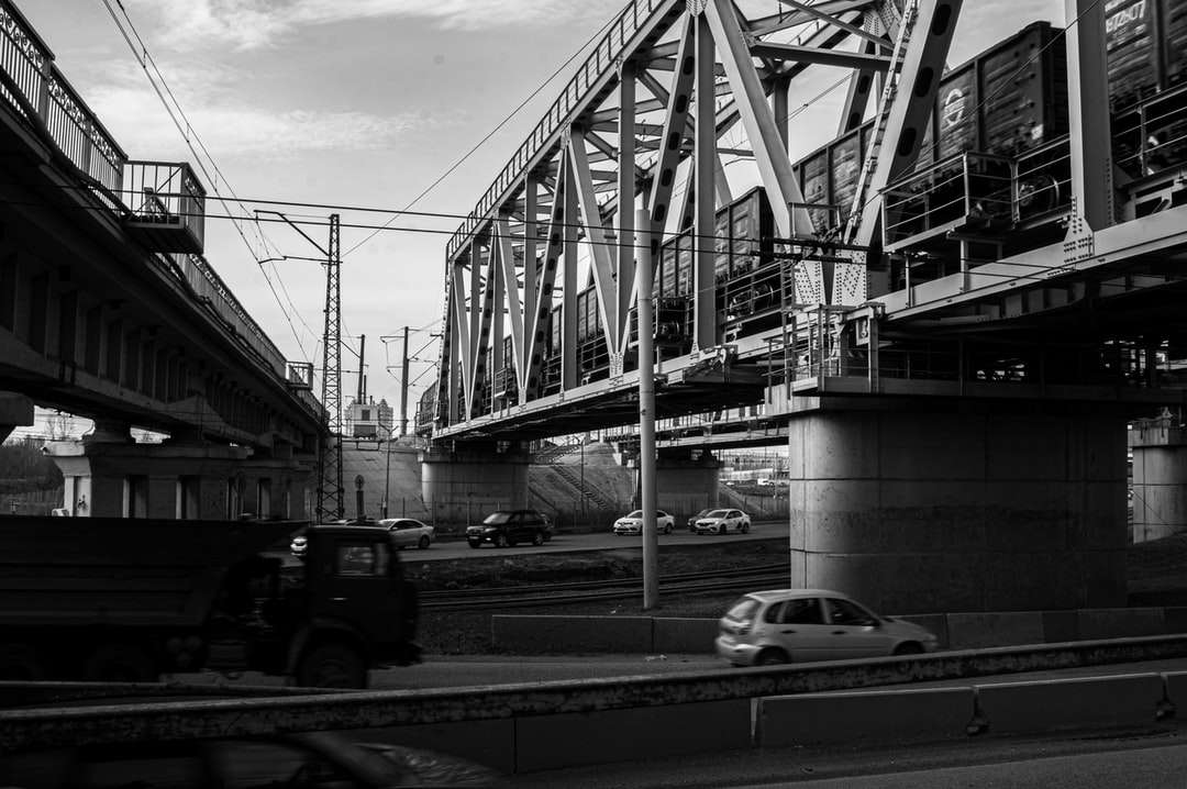 gråskala foto av bilar på väg under bro Pussel online